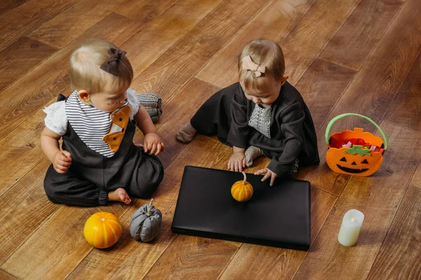 Halloween Holidays, Online Holiday party in the Time of COVID. Happy family, mother and baby celebrating Halloween near laptop, online meeting in new normal, Pandemic time.