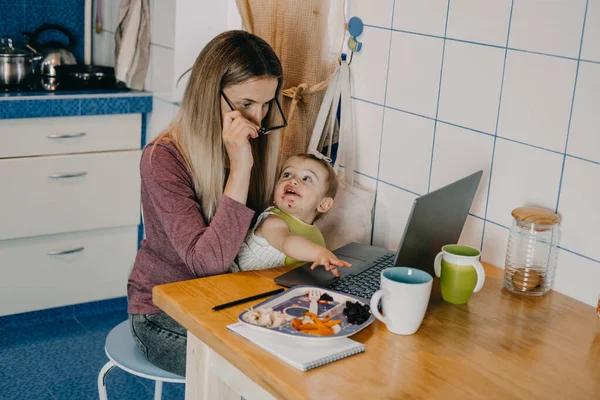 Карантин, самоизоляция, онлайн работа с детьми, занятые мамы балансируют между моим временем и семейным временем. Современная мама балансирует между работой и кормлением ребенка — стоковое фото