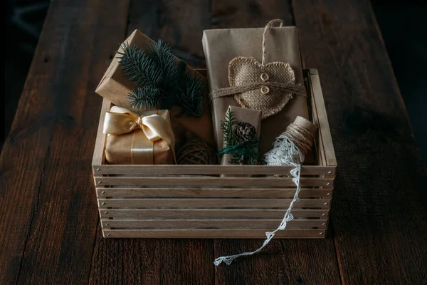 Zrównoważone Święta, zerowe prezenty, naturalne dekoracje świąteczne. Zapakowanie prezentów świątecznych w papier z recyklingu w drewnianym pudełku do pielęgnacji. Vintage stylu Boże Narodzenie pomysłów opakowań — Zdjęcie stockowe