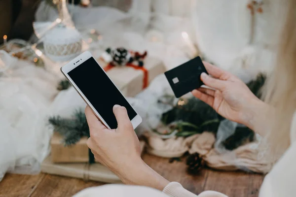 Online-Shopping, Black Friday-Verkauf, Weihnachtsgeschäft. Großaufnahme weiblicher Hände, die ein Mobiltelefon mit leerem Kopierbildschirm und Kreditkarte halten — Stockfoto