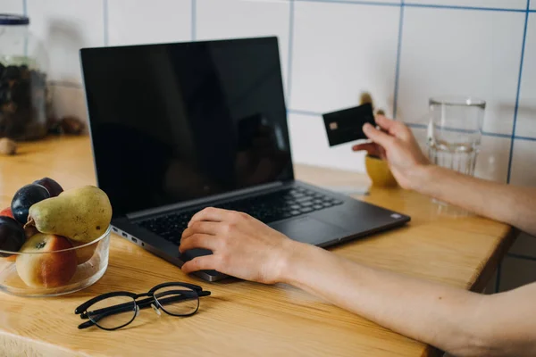 Achats impulsifs, achats en ligne, mode rapide, accro au shopping, concept d'argent de poche. Jeune femme à la maison tenant une carte de crédit et utilisant un ordinateur portable et un téléphone portable — Photo