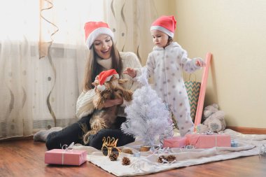 Yeni yılbaşı kutlaması. Noel 'i COVID salgınıyla kutlayan bir aile. Anne ve bebek bebek Noel tatillerini evde geçiriyorlar.