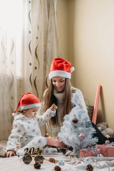 Святкування Різдва в новій нормі. Родина святкує Різдво під час пандемії COVID. Мама з малою донькою проводять вдома Xmas канікули. — стокове фото