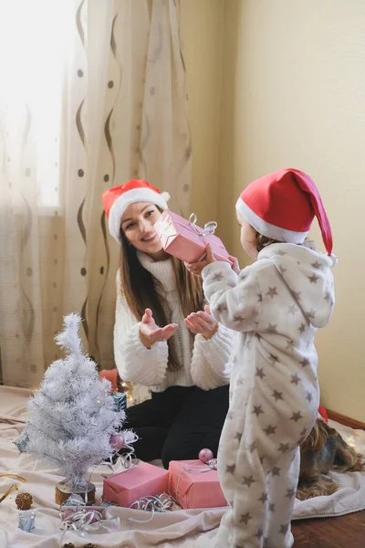 Святкування Різдва в новій нормі. Родина святкує Різдво під час пандемії COVID. Мама з малою донькою проводять вдома Xmas канікули. — стокове фото