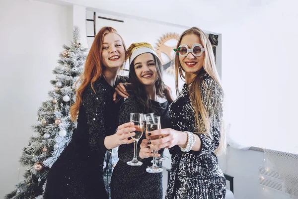 Kerstsluiting. Kerstfeest, Nieuwjaarsfeest, feestelijke familiebijeenkomsten en feestjes thuis. Drie mooie jonge vrouwen vieren Kerstmis met kleine vrienden groep. — Stockfoto