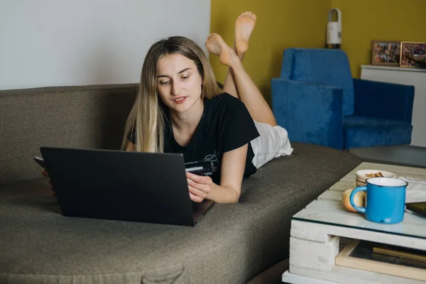 Compras en línea, Compradores inteligentes, Pagos a plazos. Mujer en casa con tarjeta de crédito y portátil para el pago en línea. Concepto de compras por Internet — Foto de Stock