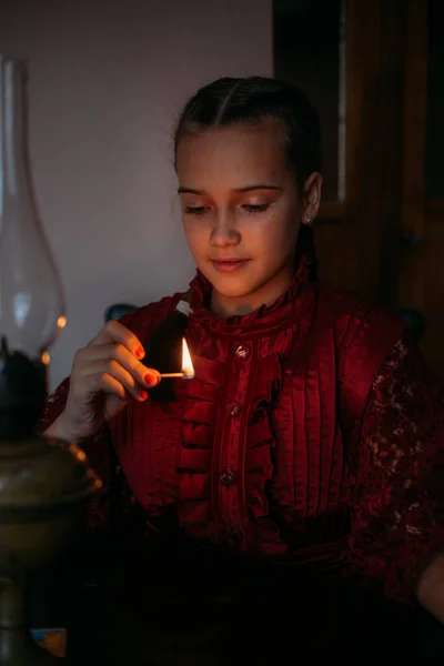 Christmas make wish, Russian Xmas traditions divination, fortune telling with candle. Portrait of young teenager girl lighting a candle and making a wish at home.