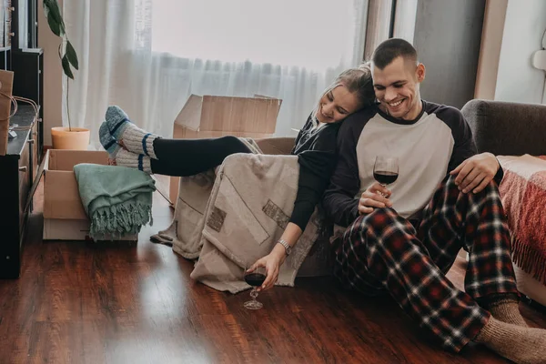 Día de mudanza, nuevo hogar, día de San Valentín, desembalaje de cajas, concepto de recién casados. Pareja celebrando mudarse a un nuevo hogar y divertirse con vino —  Fotos de Stock