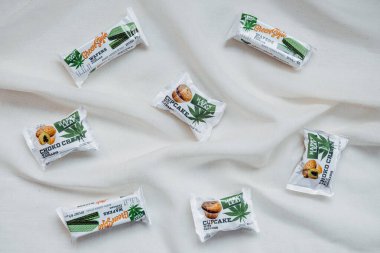 CBD Yenilebilir, CBD Enfüzyonlu Atıştırmalıklar, kekler, kenevirli gofretler. Doğal arkaplanda keten kumaştan yapılmış kase içinde lezzetli CBD çerezleri. Kropivnitskiy, Ukrayna, 20 Eylül 2020