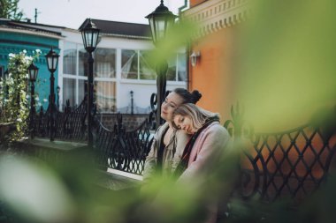 LGBT lezbiyen çift aşk anları konsepti. Sarılıp dışarıda yürüyen iki genç lezbiyen kız. Mutlu sevgililer birbirine sarılır ve el ele tutuşur.