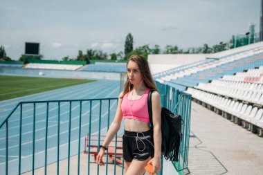 Gençler için spor, gençler için fiziksel aktivite. Genç kız spor yapıyor, koşuyor, stadyumda egzersiz yapıyor.