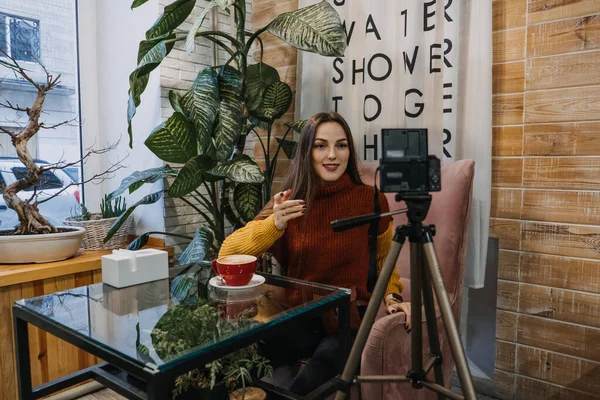 Twórca treści, bloger, vlogger konfigurowanie sprzętu do nagrywania i nagrywania wideo w kawiarni lub domu. Młoda kobieta robi sobie selfie, nagrywa się — Zdjęcie stockowe