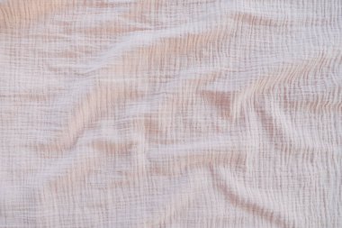 Muslin kumaş dokusu arka planda nötr tonda. Sade kumaştan yapılmış pamuklu kumaş. Muslin yumuşak, dokunmuş, yüzde yüz pamuklu, bebek bezleri ve battaniyeleriyle popüler bir kumaştır.