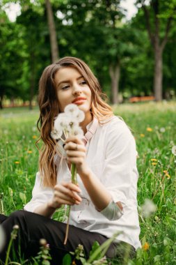 İş hayatı dengesi, refahın esasları, iş ve özel hayat arasındaki uyum. Resmi takım elbiseli genç iş kadınları halka açık parkta eğleniyor.