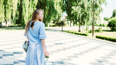 Alkolsüz yaz içkisi, ferahlatıcı soğuk içecek. Genç sarışın kadın Summer City caddesinde alkolsüz mojito içiyor..