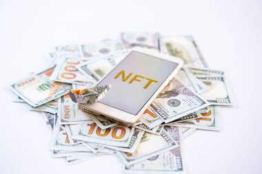 Finansal olmayan marka NFT, kripto sanat, dijital sanat, yeni tür şifreleme. Altın çerçeveli altın NFT metin ile cep telefonu dolar arkaplan üzerinde sanat nesnesi olarak