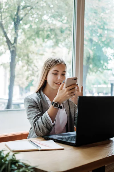 Virtual assistant, independent contractor, administrative services to clients, operating outside, home office. Young woman talking on the phone and working with laptop in home office