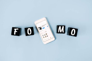 FOMO, kaçırılma korkusu, sosyal anksiyete, sürekli bağlı kalma, pişmanlık korkusu, sosyal ağ kurma. Klüp binası simgeleriyle cep telefonlu FOMO metni. Kropivnitskiy, Ukrayna, 20 Mart 2021