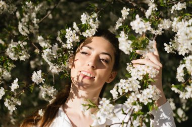 Bahar zamanı, doğal güzellik. Kiraz çiçekli bahçedeki genç kadınların samimi portresi. Bahar bahçesindeki güzel kadın, çiçek açan kiraz ağaçları.