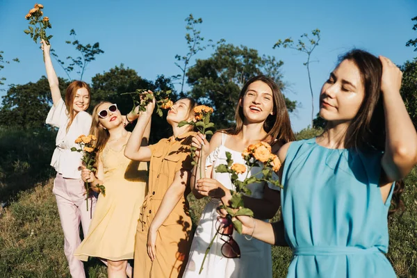 一群快乐的年轻女性，女性朋友们在夏天的自然背景上尽情玩乐。许多年轻的女性朋友在一起看日落.女性友谊和永远的朋友概念 — 图库照片