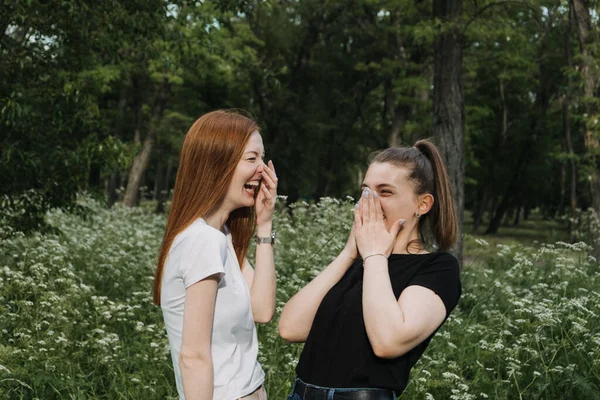 Amistad, General Z, Hermanas, gemelas. Dos mujeres jóvenes pelirrojos y de cabello castaño, novias en camiseta blanca y negra divirtiéndose en el parque. dos novias divertirse, reír, sonreír —  Fotos de Stock