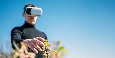 Sanal Gerçekliğin Zararlı Etkileri. Gizli risk, sanal gerçeklik tehlikesi. VR kulaklıklar sağlığa zararlı. VR gözlüklü adam doğanın tadını çıkarıyor..