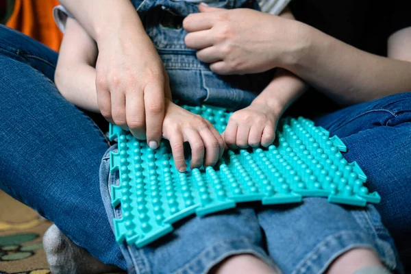 Juego sensorial para niños con necesidades especiales. Actividades para niños con discapacidad, Parálisis Cerebral. Niño con parálisis cerebral jugando con alfombra sensorial juego de masaje rompecabezas esteras para niños —  Fotos de Stock