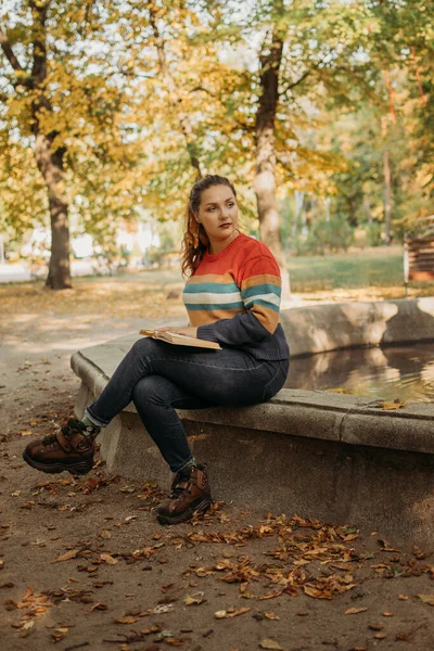 Młoda plus rozmiar kobieta czyta książki jesienią parku w słońcu. Pozytywne dla ciała, różnorodność, neutralność ciała, pozytywność ciała, rozdzielczość samodoskonalenia — Zdjęcie stockowe