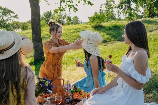 COVID Safe Summer picnic. Summer Party Ideas. Safe and Festive Ways to Host Small, Outdoor Gathering with friends. People safely get together. Young women girl friends at picnic.