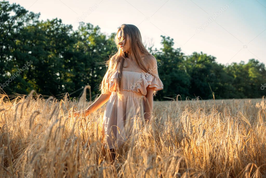 Nature mental health benefits. Connection to Nature, time outside, outdoor day off. Nature deficit disorder. Young woman enjoying nature on wheat field at sunset.