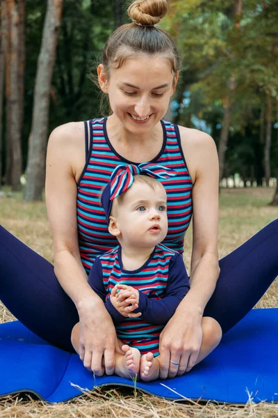 Mutter und Baby Yoga Outdoor-Kurse. Wellness, Familien-Yoga-Kurs, Üben von Achtsamkeit und Meditation, Konzept für körperliche und geistige Gesundheit für Mütter. — Stockfoto