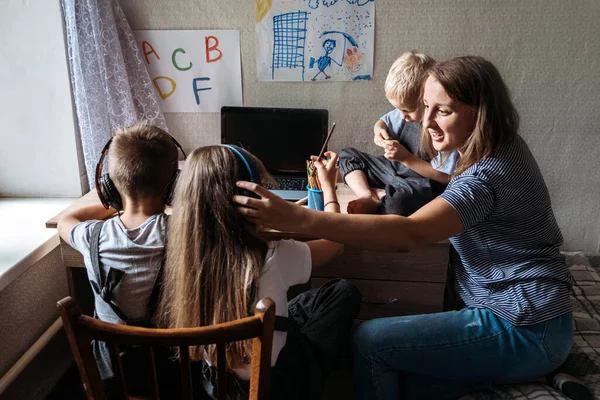 Schulkinder Jungen und Mädchen mit Mama verwenden Laptop für das Online-Lernen während der Hausaufgabenbetreuung zu Hause. Homeschooling, Online-Studium, Quarantäne zu Hause — Stockfoto