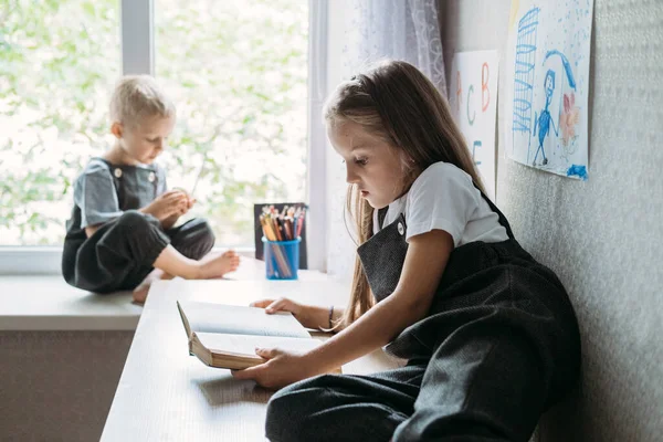 Zurück zur Schule, Homeschooling, Online-Lernen, Online-Unterricht in Quarantäne zu Hause. Schulkinder lesen während der Schulzeit zu Hause Bücher — Stockfoto