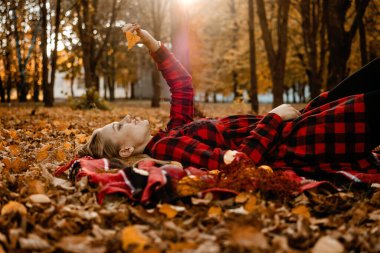 Sonbahar pikniği fikirleri, sonbahar tatili, yalnız piknik, kendi kendine çıkma, kendi başına yapacak işler. Yalnız genç kadın sonbahar parkında hayatın tadını çıkarıyor.
