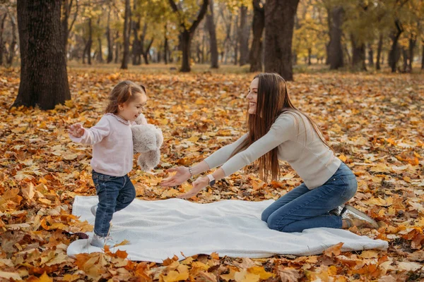 Feliz familia mamá y niña pequeña jugando al aire libre en el parque de otoño. Niña y su madre en el parque de otoño. Actividades de otoño para niños pequeños —  Fotos de Stock