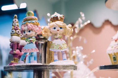 Tatlı temalı taçlarla süslenmiş tatlı pastel heykelcikler güzel bir Noel ortamında sergileniyor. Tuhaf bir tatil dekoru. Varşova, Polonya, 20 Kasım 2024.