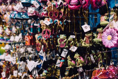 Kurbağalar, barış işaretleri, otobüsler ve parlak dudaklar da dahil olmak üzere tuhaf Noel süsleriyle dolu canlı bir perakende duvarı. Retro tatil dekoru. Varşova, Polonya, 20 Kasım 2024.