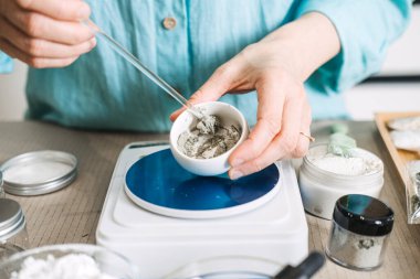 Eller, barutu dijital ölçekte küçük seramik kaseye karıştırmak için cam karıştırıcı kullanır. Postbiyotik maskeler, bariyer onarımı, pirinç mayalanması.