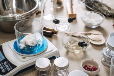 Katı yağlı cam deney şişesi, laboratuvar ekipmanları ve malzemeleriyle çevrili dijital ölçekte bulunur. Özel yağ karışımı, özel yapım yüz yağları, kişiselleştirilmiş cilt bakımı, hedeflenmiş güzellik yağları.