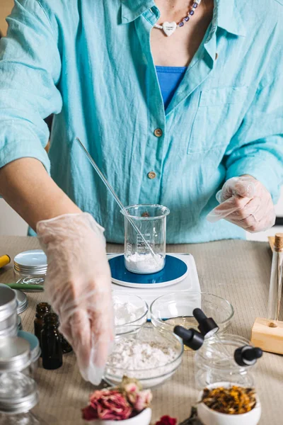 Eller plastik torbadan dijital ölçekte tutulan cam test tüpüne ince toz döker. Taze botanik cilt bakımı, bitkisel mikro doz, çiğ güzellik malzemeleri, yavaş kozmetik ürünleri.