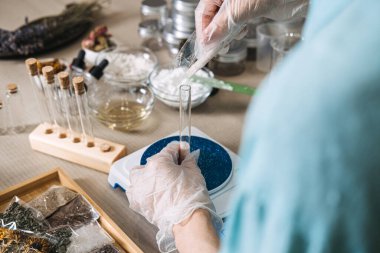 Eldiven içindeki eller eczacılık atölyesinde plastik torbadan cam test tüpüne toz döker. aktif kuru toz, sıfır koruyucu DIY, susuz raf ömrü, saf botanik karışımı