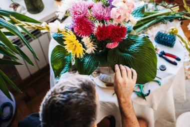 İnsanın elleri mor çiçeği yıldız çiçeği ve asterlerle büyük bir bukete yerleştirir. Zihinsel sağlık hobileri, dokunsal iyileştirme, huzurlu ev ortamı, yaratıcı meditasyon, duygusal sağIık