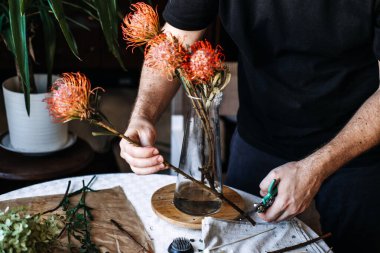 Yaratıcı botanik etkileşimi yoluyla zihinsel refahı ve bilinçli varlığı arttırmak için çiçek aranjmanı yapan elleri kapatın..