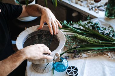 Çiçek aranjmanı için tel örgüyü taştan vazoya yerleştirin. Sürdürülebilir çiçek tasarımı, plastiksiz çiçekçi, çevre dostu çiçek düzenleme