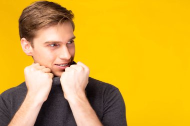 Portre genç yakışıklı beyaz adam gülümseyen yüzlü fotokopi odasına bak. Stüdyo resmi sarı arka planda izole. Çekici yakışıklı adam kendine güven, çekici moda ve saç stili konsepti.