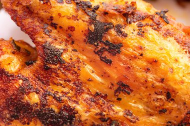 Altın renginde kızarmış tavuk budu ve deri makro yakın çekim. .