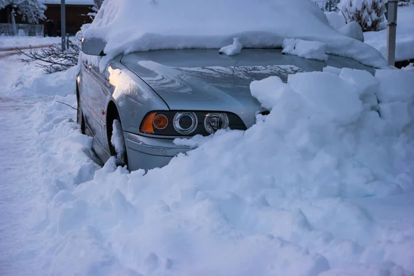 Snow covered generic car stuck in a parking place due to record high snowfall in Zurich city Switzerland late evening.