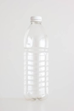 Beyaz dikey çekimde kırmızı kapaklı boş plastik şişeyi temizle.