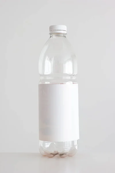 透明的空塑料瓶 红色盖子 白色空白标签 白色垂直枪弹隔离 — 图库照片