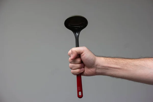 Mão Masculina Caucasiana Segurando Uma Concha Cozinha Plástico Preto Com — Fotografia de Stock